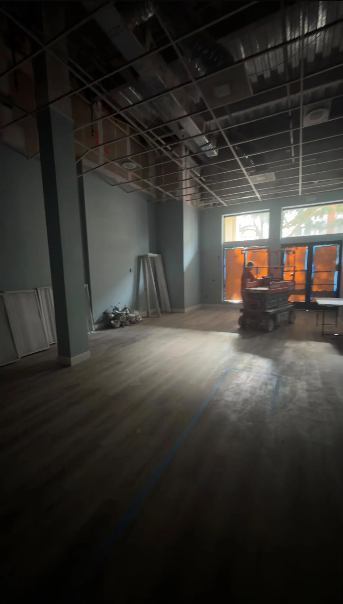 Commercial space during the work, with the ceiling open and a lift on site